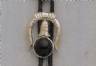 Black round stone mounted under a horseshoe shaped silver colored slide.
